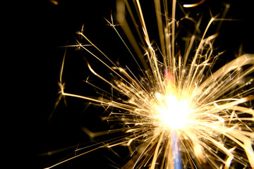 Firework background / A sparkler is a type of hand-held firework that burns slowly while emitting colored flames, sparks, and other effects