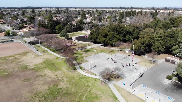Beautiful aerial drone shot of a suburban Park in Clovis California with a United States Flag.