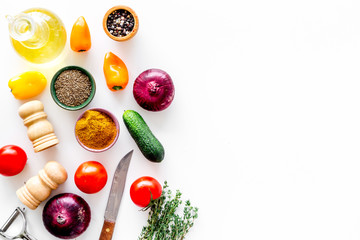 Vegetarian food concept. Set of vegetables for stew. Squash, bell pepper, tomato, spices, oil on white background top view copy space