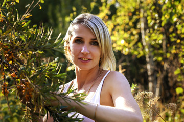 girl collects sea buckthorn in the garden