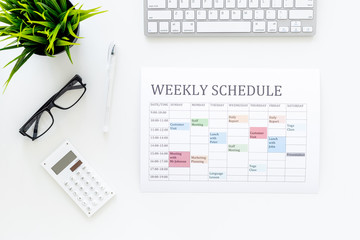 Weekly schedule. Planning the week. Multicolored planner on manager, marketologist's white office...