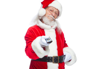 Christmas. Santa Claus in white gloves holding a TV remote control. Browse Christmas TV listings, select the channel. Isolated on white background.