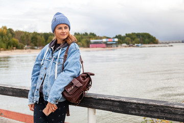 Outdoor atmospheric lifestyle photo of young beautiful  darkhaired woman  in knitting hat, in a...