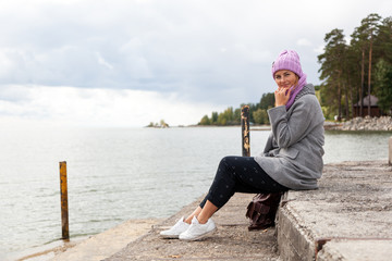 Outdoor atmospheric lifestyle photo of young beautiful  darkhaired woman  in knitting hat, in a...