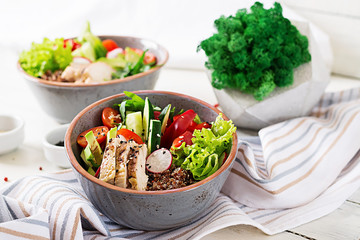 Buddha bowl dish with chicken fillet, quinoa, avocado, sweet pepper, tomato, cucumber, radish, fresh lettuce salad and sesame. Detox and healthy superfoods breakfast bowl concept.