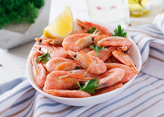 Boiled  shrimps or prawns on a white bowl on a white table. Seafood.