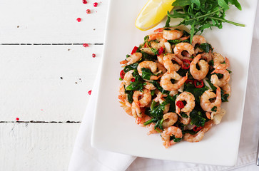Fried prawns or shrimps with spinach, chili and garlic in white plate. Diet concept. Overhead, top view, flat lay