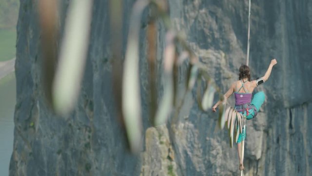 Athlete on slack line high line extreme sport over cliff tiger rope walking