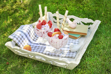 Ice cream dessert with fresh strawberries, peaches and crispy wafer rolls.