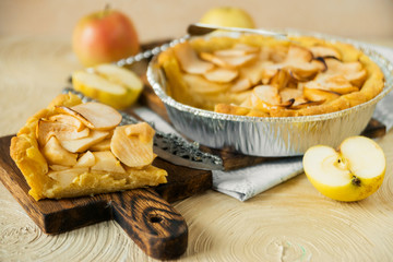 Traditional home-made autumn Apple pie-Charlotte, on a light background with appliances.