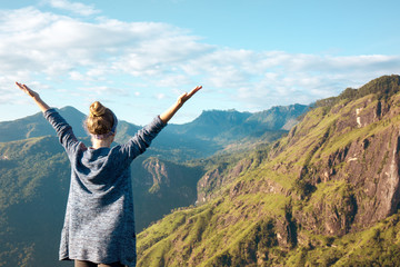 Happy woman on top of a mountain