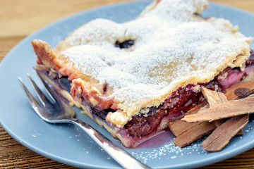 Plum tart with cinnamon. Delicious homemade plum baked goods. Portion of cake on a plate with shallow depth of field.