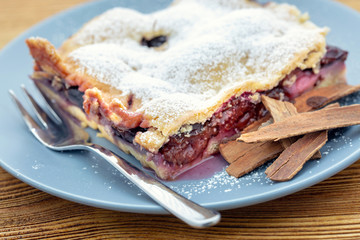 Plum tart with cinnamon. Delicious homemade plum baked goods. Portion of cake on a plate with shallow depth of field.