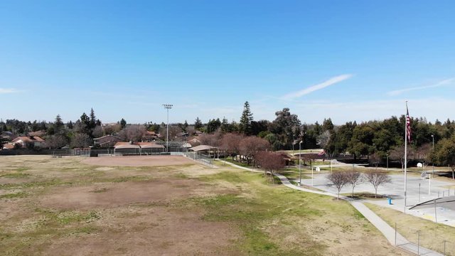 Beautiful aerial drone shot of a suburban Park in Clovis California with a United States Flag.