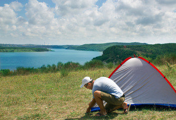 Camper is pitching the camping tent. Campsite holiday nature summertime consept. Outdoors nature camping vacation theme.