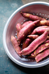 Purple sweet potato in a metal colander, close-up