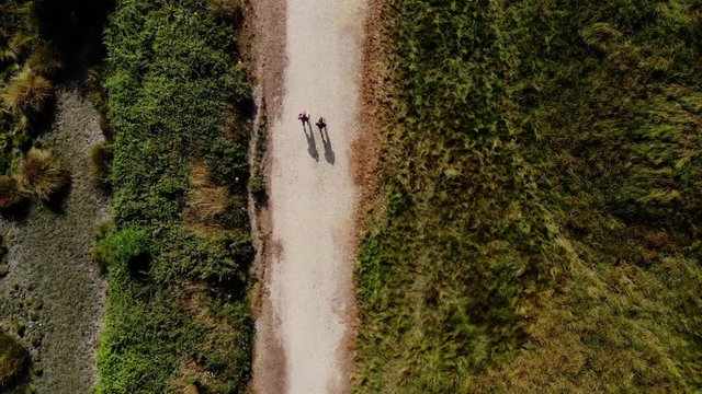 Aerial top down shot of two people walking along a path