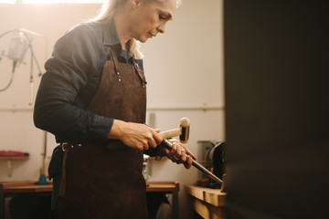 Professional female jeweler making jewelry