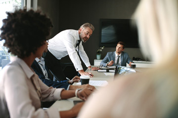 Senior executive explaining something to his team in a meeting