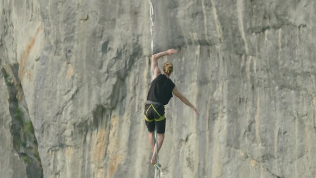 Athlete on high line slack line over cliff in Germany