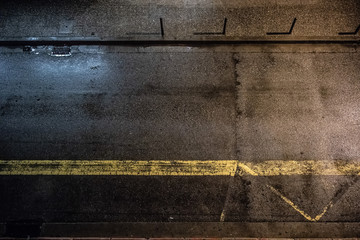 Black tarmac road bright by the rain night scene with yellow line painted