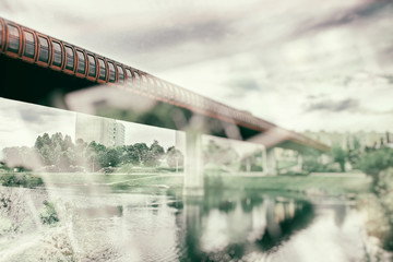 Double exposure of the bridge over the river, after which the metro train runs in the big city. It is retro style photo. 