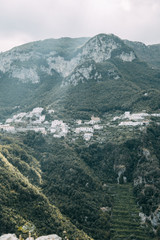 The Amalfi coast and the mountain slopes with plantations of lemons. Panoramic view of the city and nature of Italy. Evening landscapes and winding roads