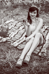 Naklejka premium Young sweet woman on picnic outside with apples. Autumn time. Vintage retro pin up style and pretty day. Concept of 50s style 