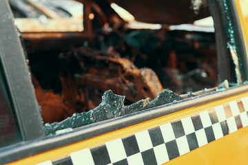 The yellow taxi that has burnt down the car which has suffered from a strong fire in a city parking...