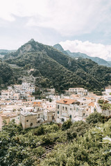 Obraz premium The Amalfi coast and the mountain slopes with plantations of lemons. Panoramic view of the city and nature of Italy. Evening landscapes and winding roads