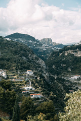 Obraz premium The Amalfi coast and the mountain slopes with plantations of lemons. Panoramic view of the city and nature of Italy. Evening landscapes and winding roads