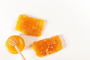 jar of honey and stick isolated on white background