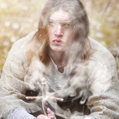 A man in a cassock spends a ritual in a dark forest