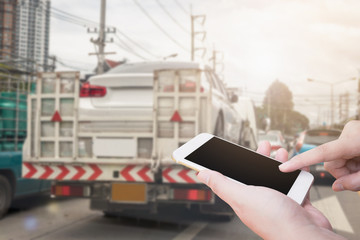 using mobile smartphone for emergency roadside service with Broken car on tow truck after traffic...