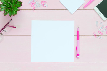 Feminine desk workspace with succulent, glasses, and paper for copyspace