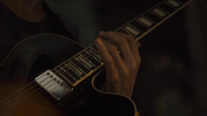 Guitar player playing rock music on concert stage. Close up hands of musician playing music at acoustic guitar. Guitarist plays melody on strings.