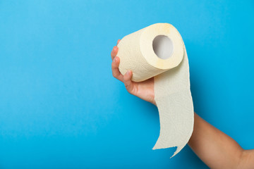 Bathroom toilet paper roll in hand, hygiene tissue sanitary concept.