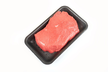 Big red meat chunk in package, on white background