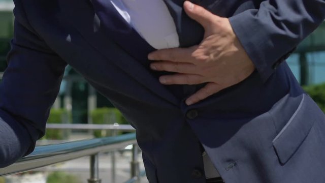 Businessman having heart attack stressful life consequences, man needs first aid