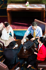 Overhead view of business people handshaking in office during meeting