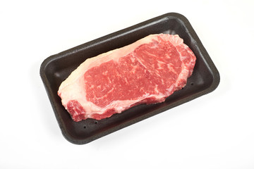 Raw beef steak in a tray isolated on white background.