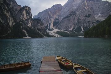 Breathtaking landscape scenic view of romantic, tourist popular alpine lake Lago Di Braies (Pragser Wildsee) in Dolomites mountains, Italy with iconic wooden boats on clear water.Lake activity concept