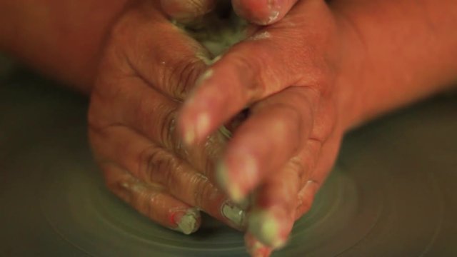 ceramic for  beginners- hands throwing a clay vessal on a pottery wheel