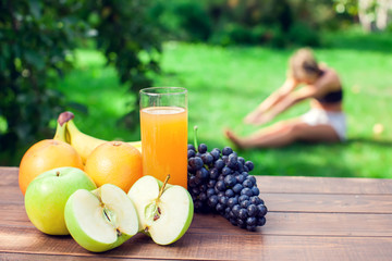 Lifestyle, sport and healthcare. A woman during yoga exercises outdoor. Healthy food on the table