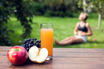 Lifestyle, sport and healthcare. A woman during yoga exercises outdoor. Healthy food on the table