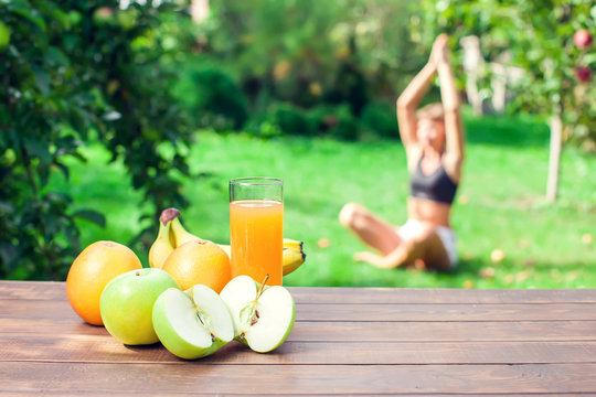 Lifestyle, sport and healthcare. A woman during yoga exercises outdoor. Healthy food on the table