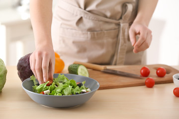 Woman preparing tasty salad at table. Diet food