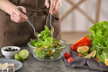 Woman preparing tasty salad at table. Diet food