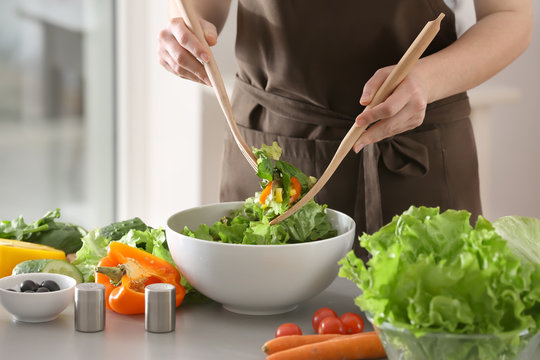 Woman preparing tasty salad at table. Diet food