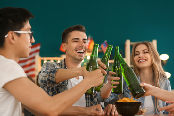 Group of cheerful friends drinking beer in bar